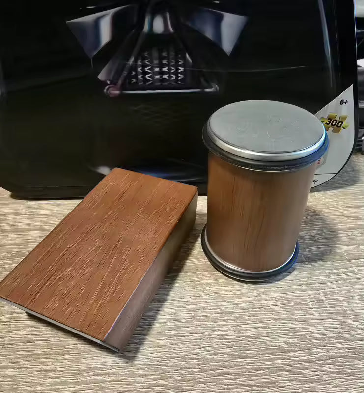 Wooden block and cylindrical object with metal lid on a textured surface