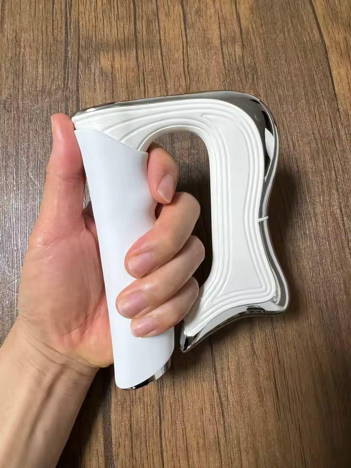 Hand holding a white iron with a wooden surface in the background